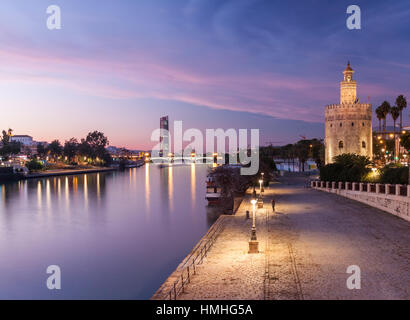 Views from Puente de San Telmo of the Torre del Oro, Torre Sevilla and Río Guadalquivir at dusk Stock Photo