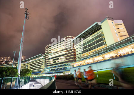 Local Hong Kong runners running around the track at Happy Valley Stadium, Hong Kong Stock Photo