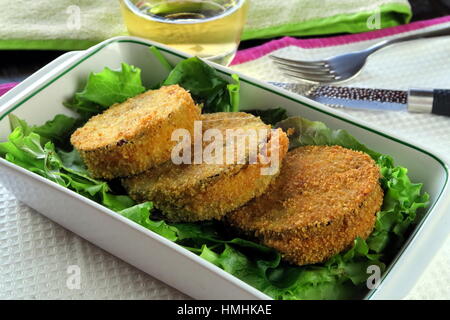 Aubergine and melted cheese vegetarian deep fried Cordon Bleu served in a white baking dish - French / Italian recipe veggie variant