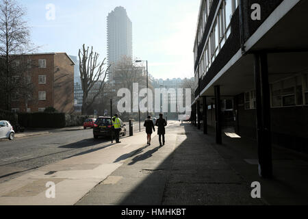 A rear back view of couple walking along Golden Lane looking towards the Barbican Estate, London EC2Y  KATHY DEWITT Stock Photo