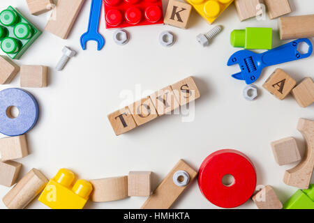 Toys word written in wooden cubes. Children toy on white background as frame with copy space for text. Top view Stock Photo