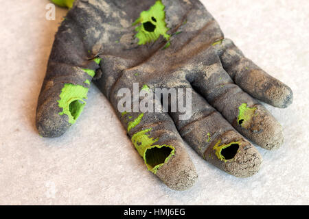 Used old dirty torn worker's gloves as a metaphor, concept or symbol for the end of the work season Stock Photo