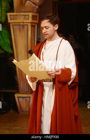A character dressed in Roman costume reads from a scroll Stock Photo