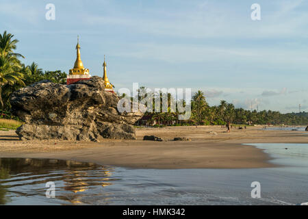 Golden pagodas on rocks at palm beach, Ngwe Saung, Myanmar Stock Photo