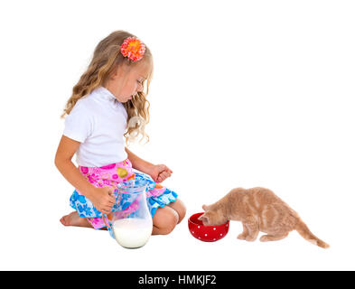 Cute little girl feeding red cat with milk. Isolated on white background Stock Photo