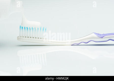 macro of putting white tooth paste on brush isolated Stock Photo