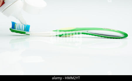 putting tooth paste on brush isolated on white Stock Photo