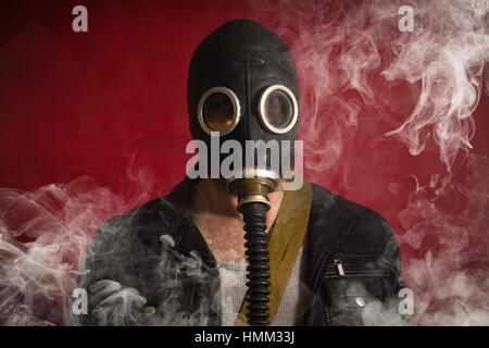 Scary man wearing authentic Russian gas mask with breathing hose Stock Photo