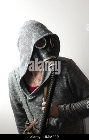 Scary man wearing authentic Russian gas mask with breathing hose Stock Photo