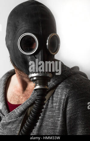 Scary man wearing authentic Russian gas mask with breathing hose Stock Photo