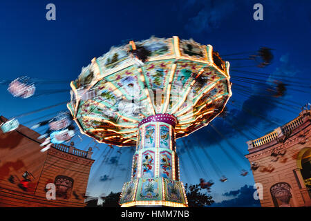 View of a Moving Chain Swing Ride at Dusk, Prater Amusement Park, Vienna, Austria Stock Photo