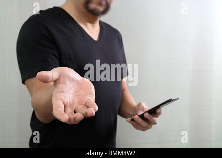Designer hand pressing an imaginary button,open hand,holding smart phone Stock Photo
