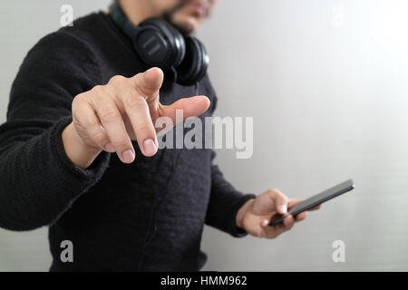 Businessman hand pressing an imaginary button,holding smart phone,digital screen graphic virtual icons,graph,diagram Stock Photo