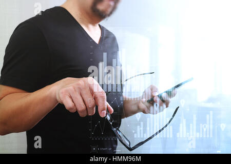 Designer hand holding eyeglasses,using smart phone,virtual computer interface omni chanel business screen Stock Photo