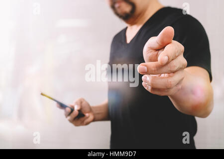 Designer hand pressing an imaginary button,holding smart phone,digital screen graphic virtual icons,graph,diagram,filter effect Stock Photo
