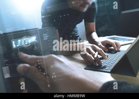 StartUp Programming Team. Website designer working digital tablet dock keyboard and computer laptop with smart phone and compact server on mable desk, Stock Photo