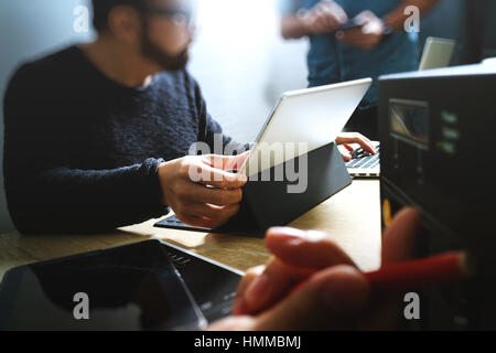 StartUp Programming Team. Website designer working digital tablet dock keyboard and computer laptop with smart phone and compact server on mable desk, Stock Photo