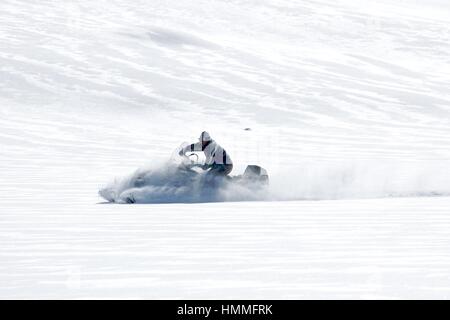 Man driving sports snowmobile in a sunny day Stock Photo