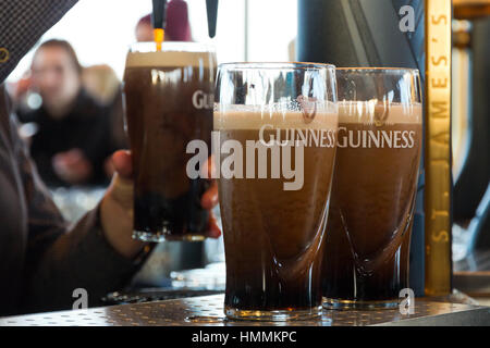 DUBLIN, IRELAND - FEB 15, 2014: Pints of beer are served at The Guinness Brewery on Feb 15, 2014. The brewery where 2.5 million pints of stout are bre Stock Photo