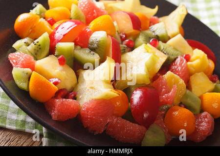 Salad of fresh exotic tropical fruits macro on a plate on the table. Horizontal Stock Photo
