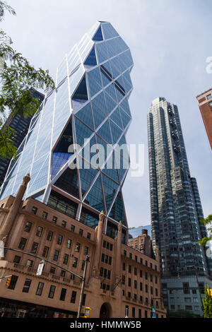 New York City - June 22: The Hearst Tower in New York between other skyscrapers with blue sky on June 22, 2013 Stock Photo