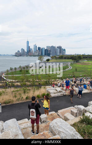 View from Outlook Hill over Grassy Hill, Governors Island, towards the skyline of New York City Stock Photo