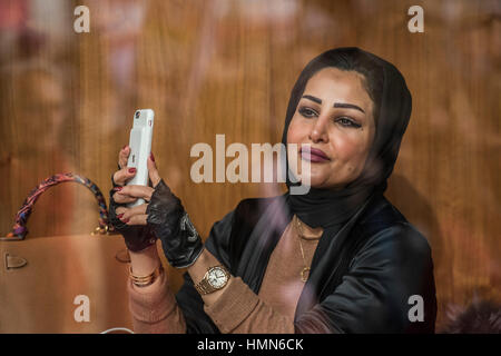 London, UK. 4th February, 2017. A muslim woman in a smart, Park Lane, hotel films the march as it goes past - A march against racism and to ban the ban (against immigration from certain countries to the USA) is organised by Stand Up To Racism and supported by Stop the War and several unions. It stated with a rally at the US Embassy in grosvenor Square and ended up in Whitehall outside Downing Street. Thousands of people of all races and ages attended. Credit: Guy Bell/Alamy Live News Stock Photo