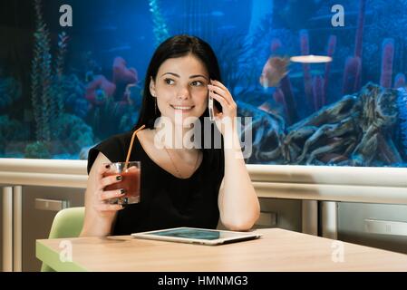 Brunette woman talking on a cellphone indoors Stock Photo