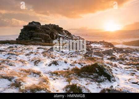 Golden sunset on snow covered Higher Tor Dartmoor National Park Devon UK Stock Photo