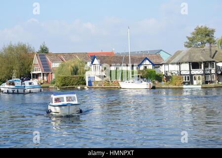 Wroxham Norfolk  , United Kingdom - October 25, 2016: Pleasure boats  on  River Yare centre for tourism on Norfolk Broads with houses  in background Stock Photo