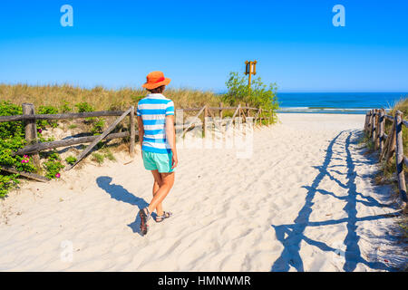 Young woman walking on white sand to beautiful Lubiatowo beach, Baltic Sea, Poland Stock Photo