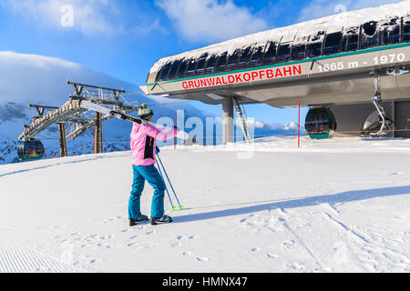 OBERTAUERN SKI RESORT, AUSTRIA - JAN 19, 2017: young woman skier standing in front of a lift in Obertauern skiing area on sunny winter day, Salzburg landAustria. Stock Photo