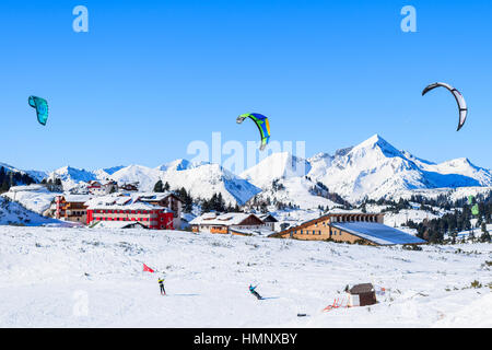 OBERTAUERN SKI RESORT, AUSTRIA - JAN 22, 2017: skiers with kites flying in Obertauern ski area in Salzburg land, Austrian Alps. Stock Photo