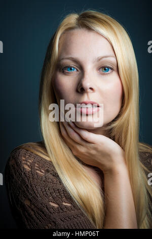 Studio portrait of woman with long blond hair and blue eyes. Stock Photo