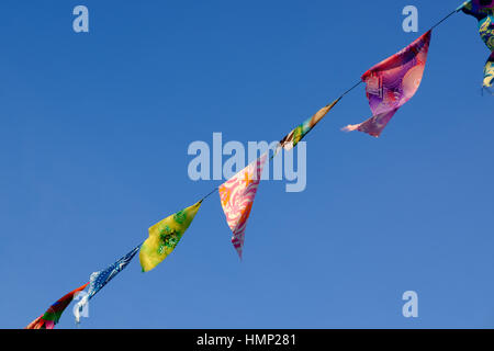 Flags and bunting against a blue sky in late afternoon Stock Photo