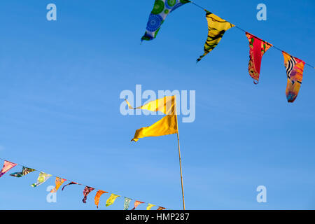 Flags and bunting against a blue sky in late afternoon Stock Photo