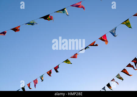 Flags and bunting against a blue sky in late afternoon Stock Photo