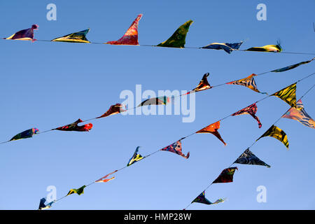 Flags and bunting against a blue sky in late afternoon Stock Photo