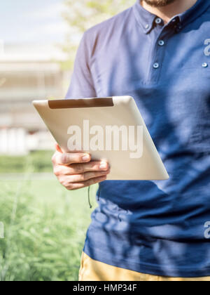 Man using a digital Tablet outdoors Stock Photo