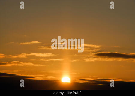 Golden sun halfway above horizon, beautiful orange sunrise scene Stock Photo