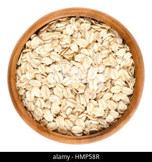 Oatmeal, rolled oats in wooden bowl. Dehusked, hulled oats, rolled into large whole flakes. Porridge oats, used in granola or muesli. Stock Photo