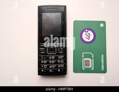 Astrakhan, Russia, 24 Dec. 2016: Cell phone and 4G SIM Card of Megafone celular phone operator, one of Big-Three operators in Russia Stock Photo
