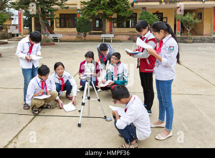 School children attending outdoor classroom, learning how to operate a sextant, Thai Giang Boarding School. Stock Photo