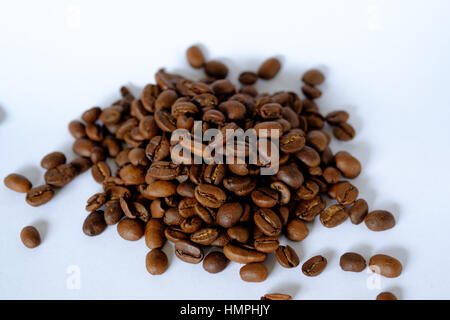 Small pile of roasted coffee beans on a white background Stock Photo