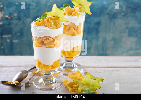 Mango and cereal yogurt parfait in tall glasses Stock Photo
