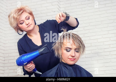 Hairdresser with hair dryer Stock Photo