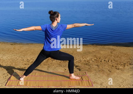 Woman practicing yoga outdoors Stock Photo