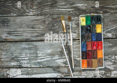 Brushes and watercolor on old wooden table Stock Photo