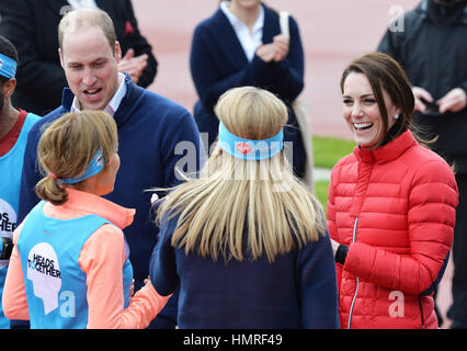 The Duke and Duchess of Cambridge laugh as they talk to Paula Radcliffe (centre) and other runners at the Queen Elizabeth Olympic Park in east London, as they joined runners taking part in the London Marathon for their mental health campaign Heads Together. Stock Photo