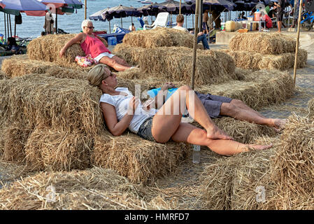 Straw bales with people relaxing outdoors Stock Photo
